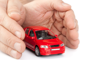 Red car in hands on a white background. Concept of safe driving